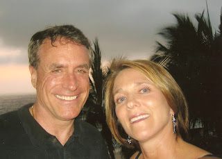 Smiling man and woman seaside selfie at sunset