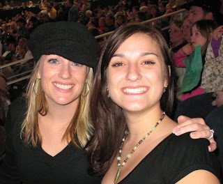 Two smiling women at crowded stadium