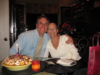 Two people smiling at table with cake