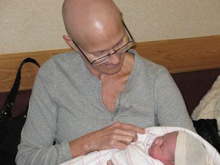 Person holding newborn baby wrapped in blanket