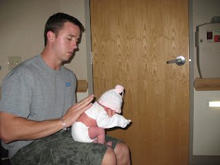 Man holding newborn baby in hospital room