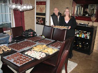 Two people with trays of assorted cookies