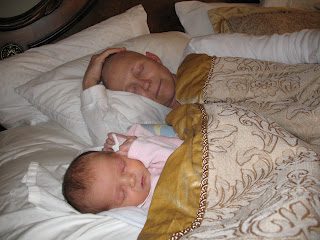 Man and baby sleeping together under blanket
