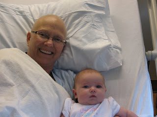 Smiling adult and baby lying on bed