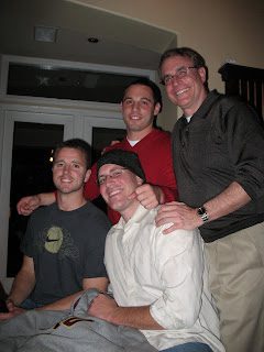 Four men smiling together indoors