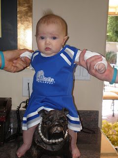 Baby in blue cheer outfit on bulldog statue