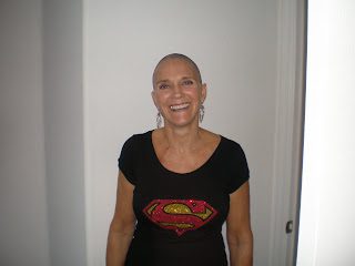 Smiling woman with shaved head wearing Superman shirt