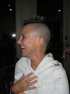 Smiling person with shaved mohawk in towel