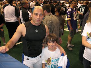 Athlete posing with smiling boy at event
