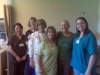 Group of six healthcare workers smiling in clinic