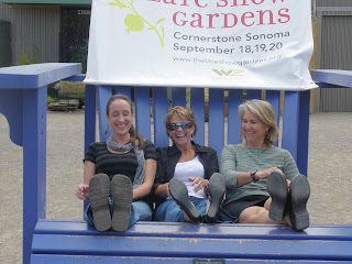 Three smiling women on giant blue chair