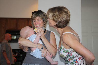Woman holding baby while another woman smiles