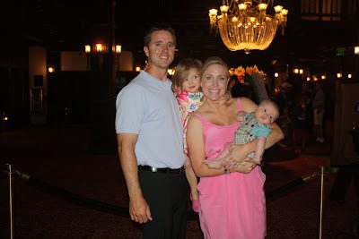 Family of four posing in chandelier-lit lobby
