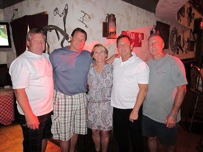 Group of five adults in dimly lit bar