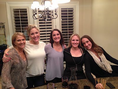 Five women smiling around kitchen island