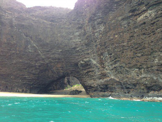 Coastal rock arch with turquoise water.