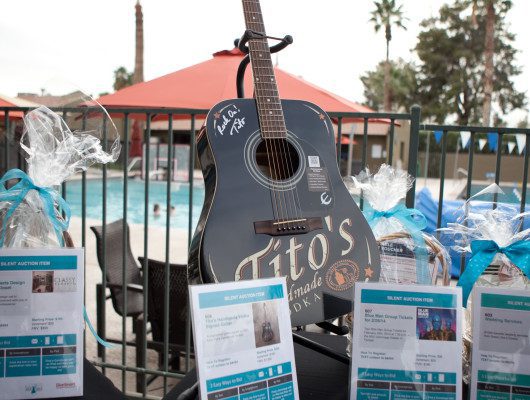 Signed guitar displayed at outdoor event.