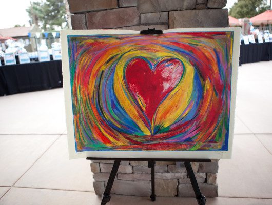 Colorful heart painting on an easel.