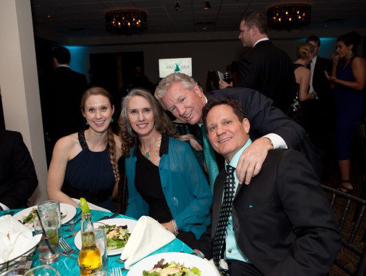 Group of people smiling at formal event.