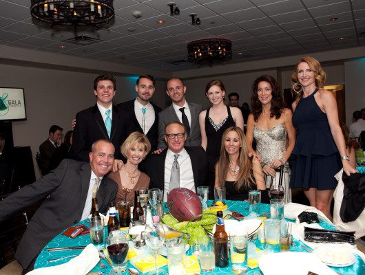 Group of people posing at formal event.