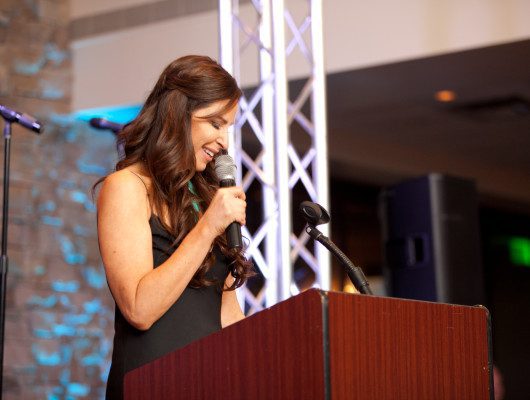 Woman speaking at podium with microphone.