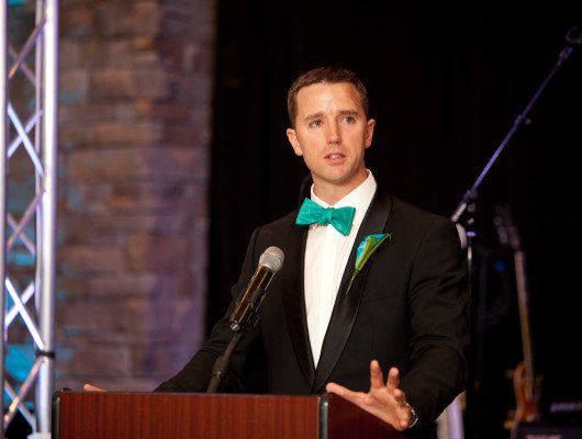 Man speaking at podium with microphone.