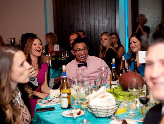 People laughing at a festive dinner event.
