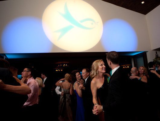 Couples dancing under blue and white lights.