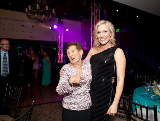 Two women smiling at a formal event.