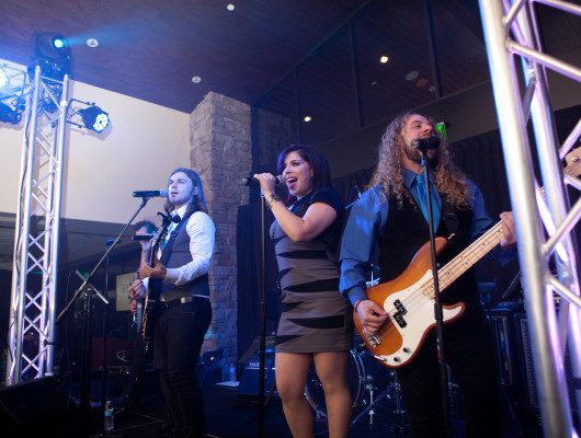 Band performing live on stage with instruments.
