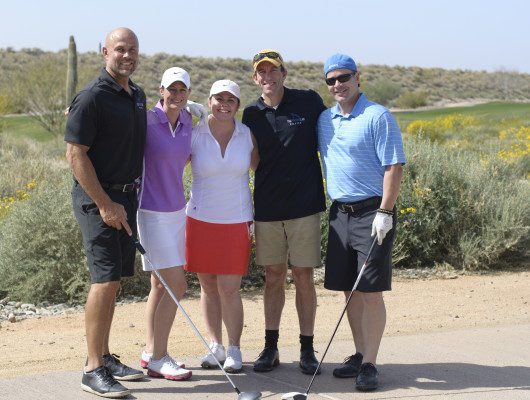 Group of golfers posing on a course.