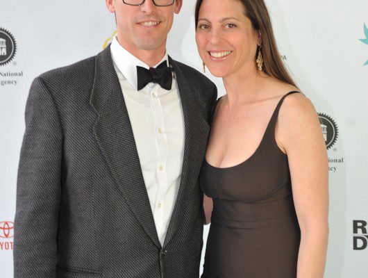 Man and woman posing at formal event.