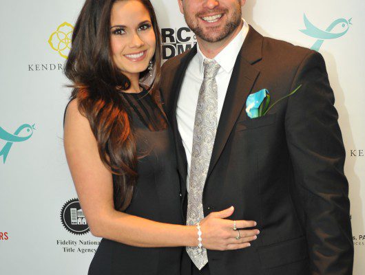 Smiling couple posing at formal event.
