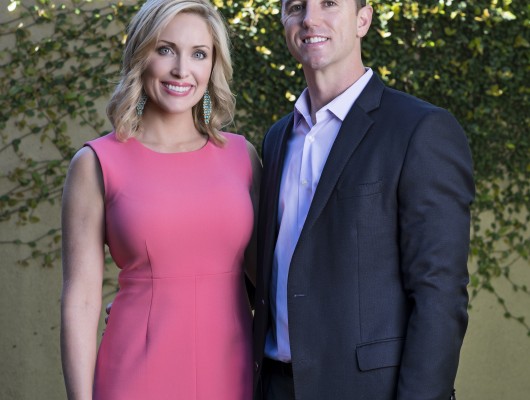 Smiling couple posing in garden setting.