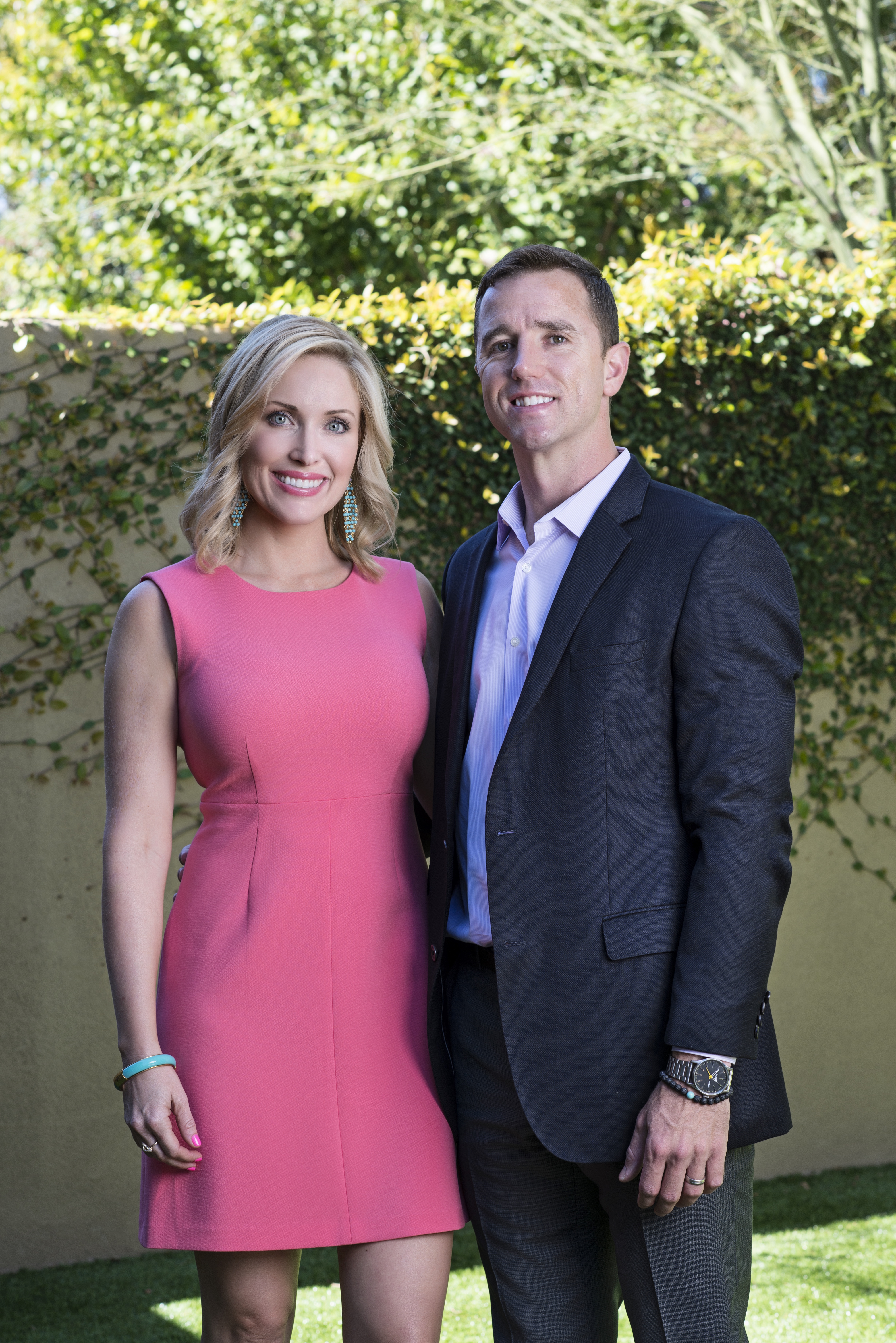Smiling couple posing in garden setting.