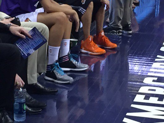 Basketball players sitting, various colorful sneakers.