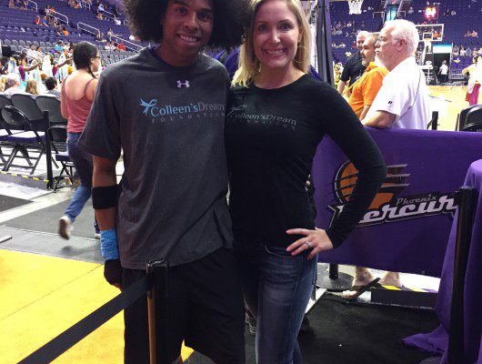 Two people posing on a basketball court.