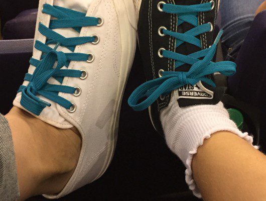 Two different sneakers with blue laces.