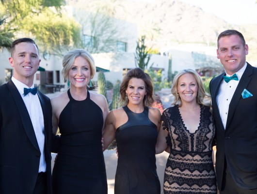 Group in formal attire outdoors, smiling.