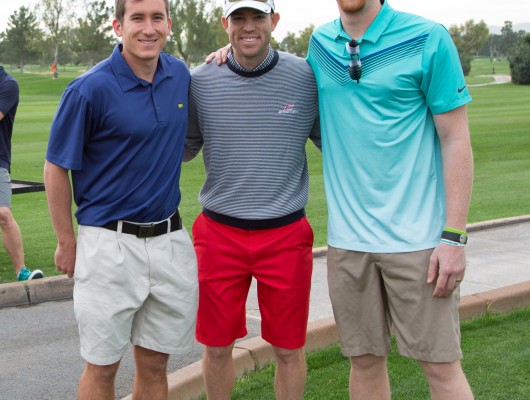 Three men posing on a golf course.