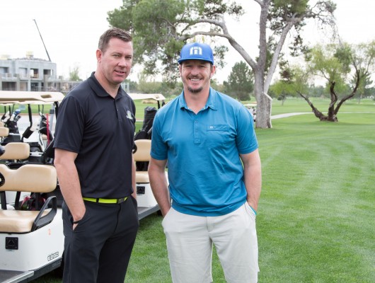Two men standing on a golf course.