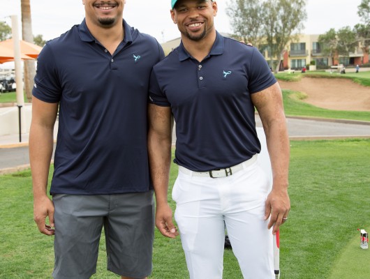 Two men posing on a golf course.