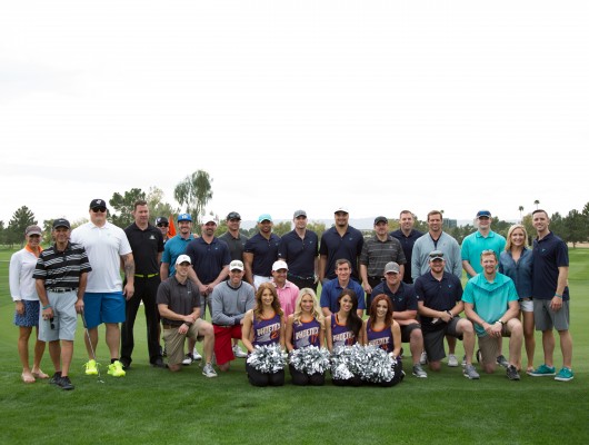 Group posing on a golf course.