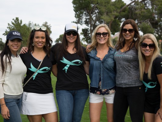 Group of women smiling on a golf course.