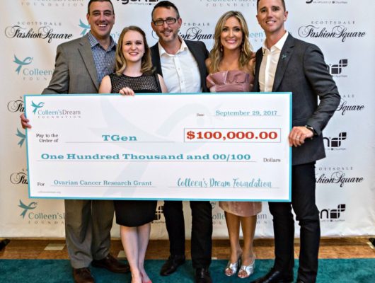 A group of people posing for a picture with a large check.