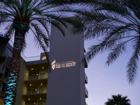 Building with palm trees at dusk.