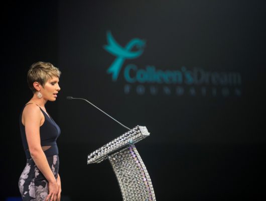 A woman standing at a podium at an event.