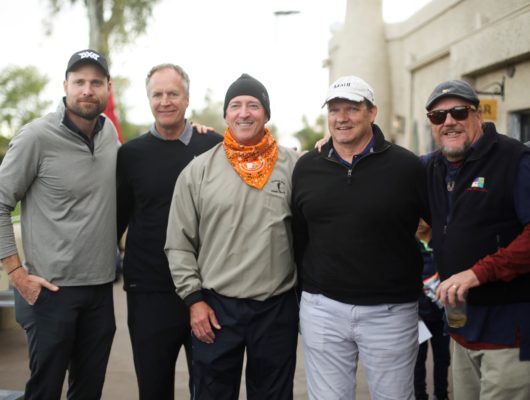 A group of men posing for a photo at a golf tournament.